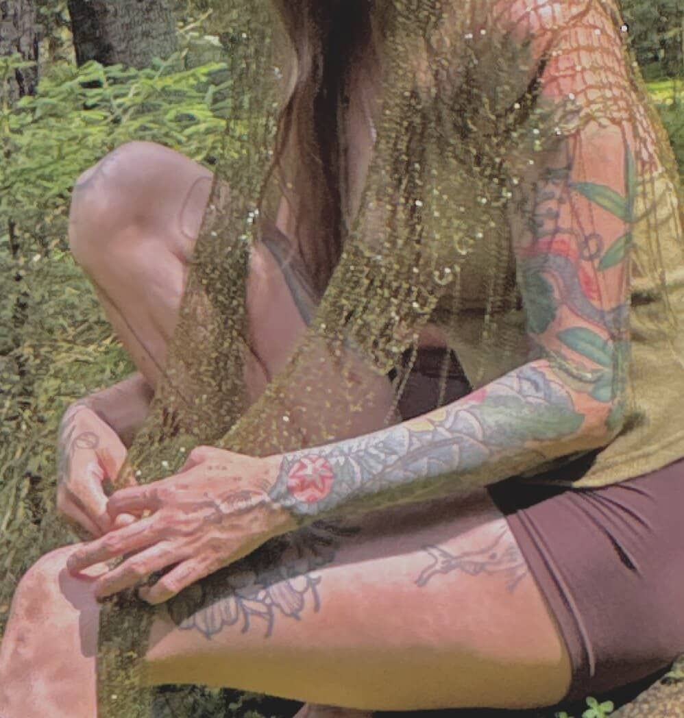 Hands working the loose gold mesh on a mossy rock.